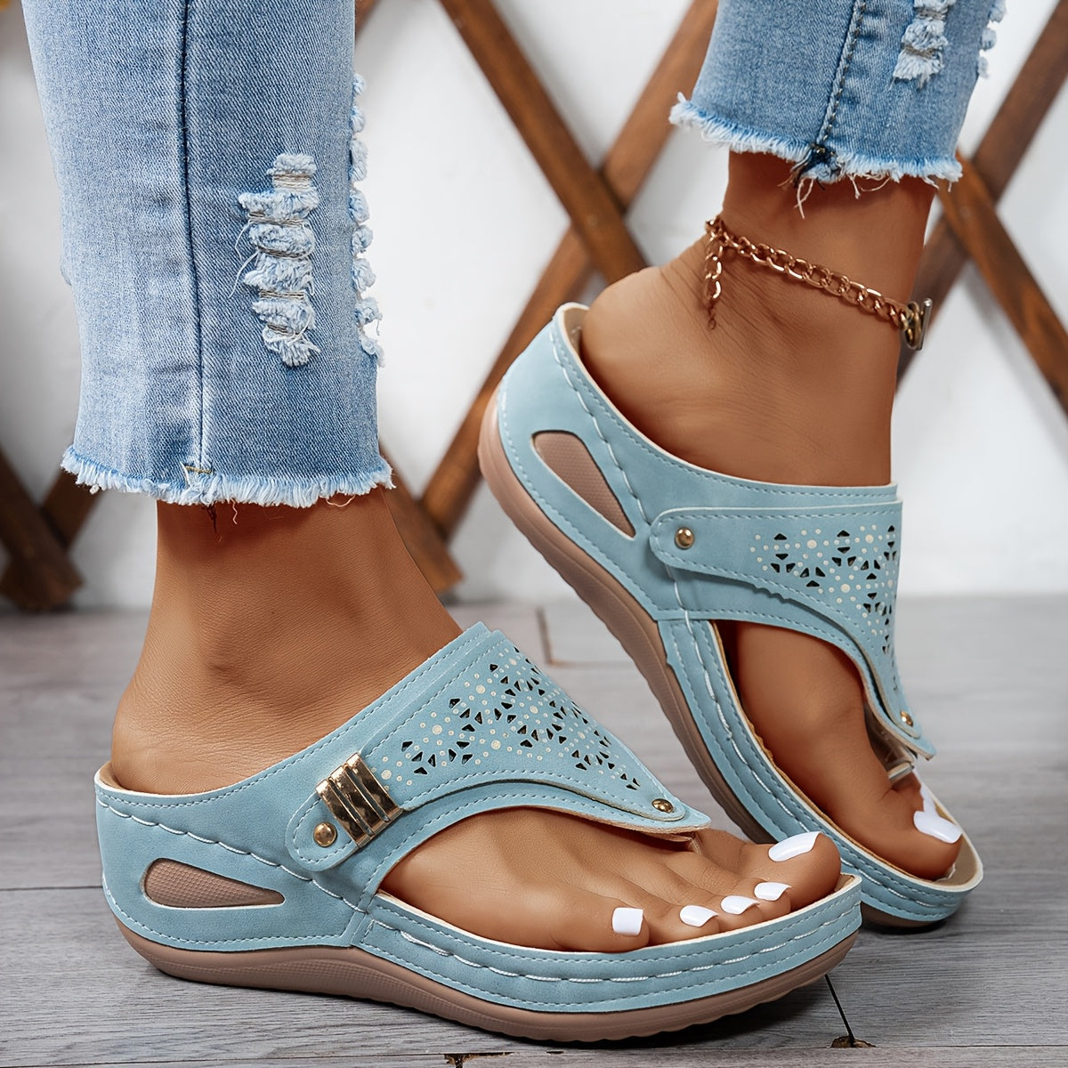 Light blue Jean sandals with cutout perforations and adjustable buckle on a comfort footbed.