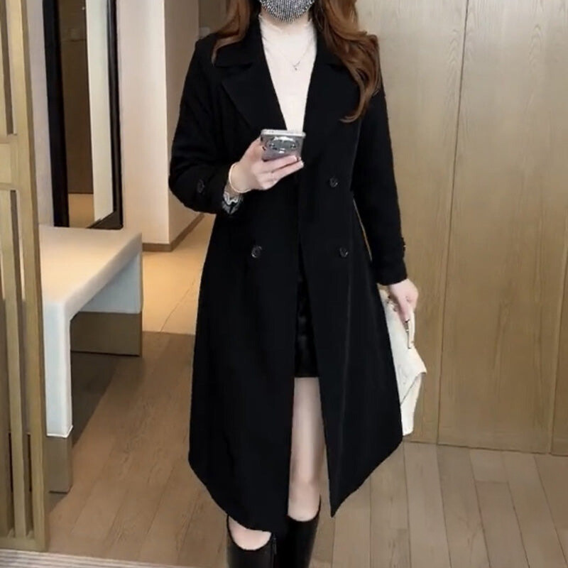 Black trench coat with notch lapels, double-breasted buttons, and long asymmetric hem