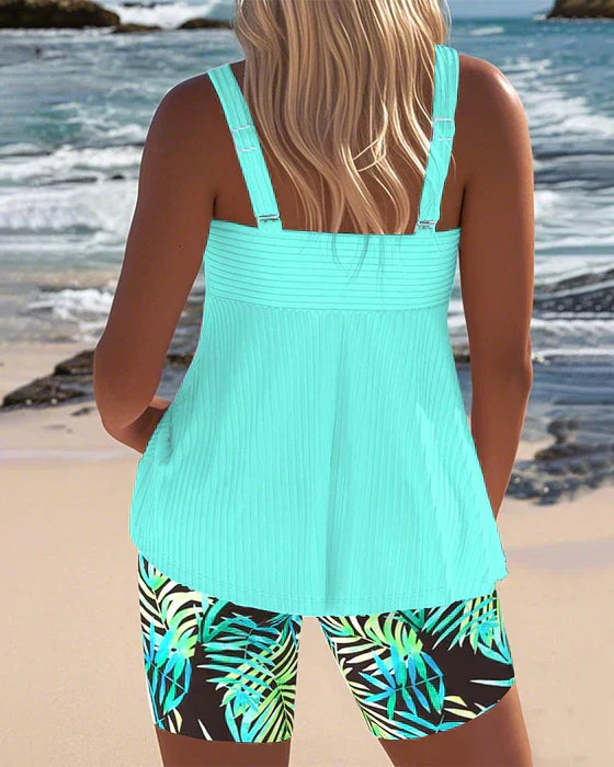 Bright ribbed tankini top and shorts (back view), cyan with tropical leaf print.