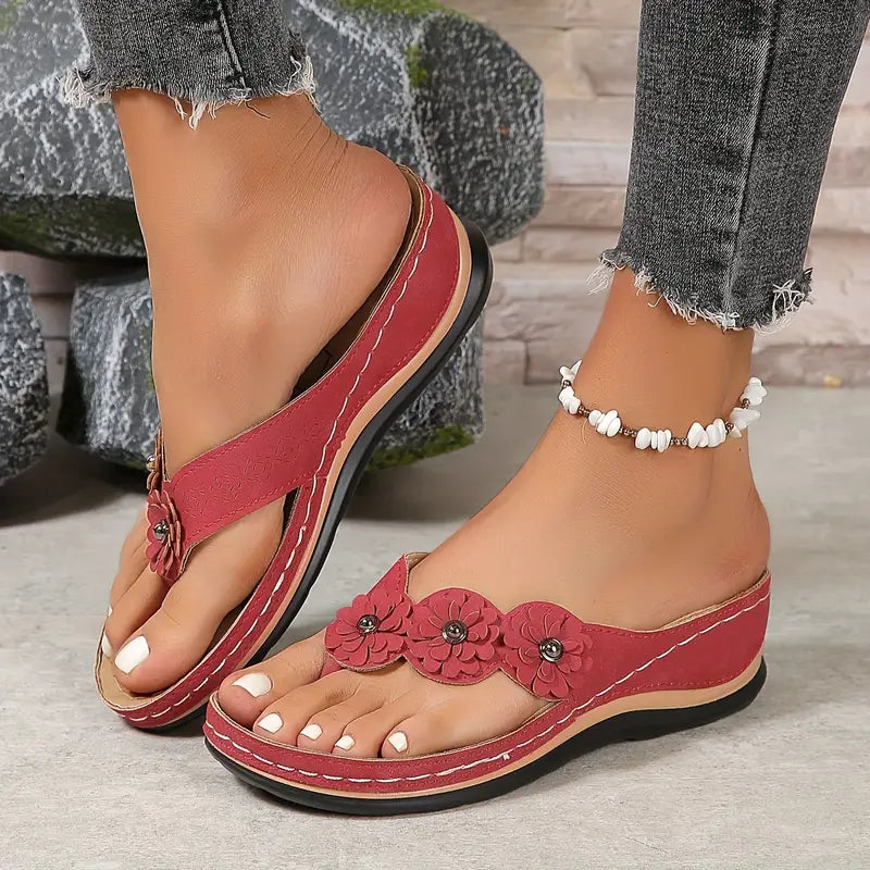 Red comfort sandals with floral applique and tassel details, plus white beaded anklet