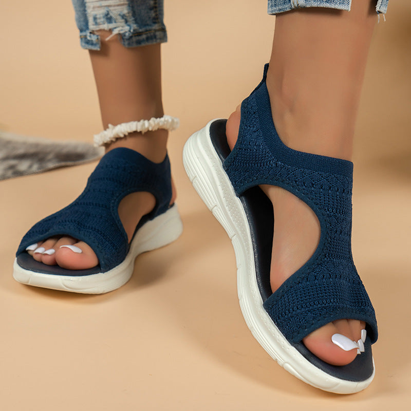 Navy blue knit sandals with cross strap and open toe, white cushioned sole
