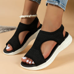 Black knit sandals with toe-out cutout and white sole, cross strap design