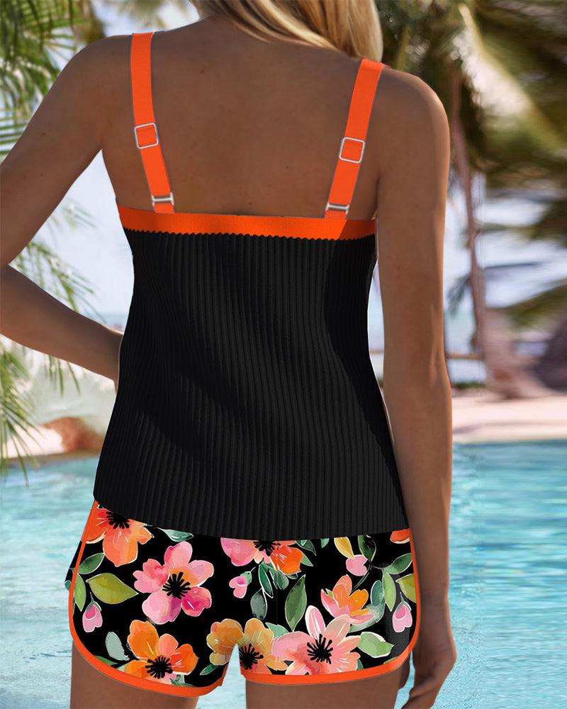 Back view of two-piece tankini set: black tank with orange straps, floral shorts