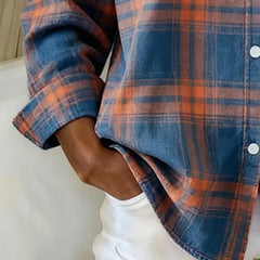 Plaid shirt sleeve detail in blue and orange with button-up placket