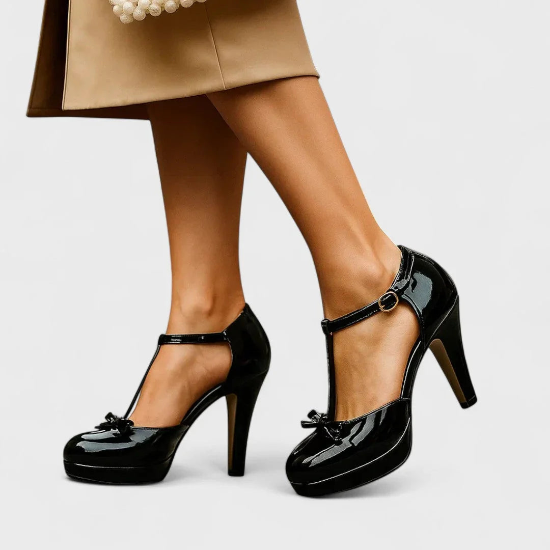 Black Mary Jane heels with ankle strap, round buckle, and glossy platform sole