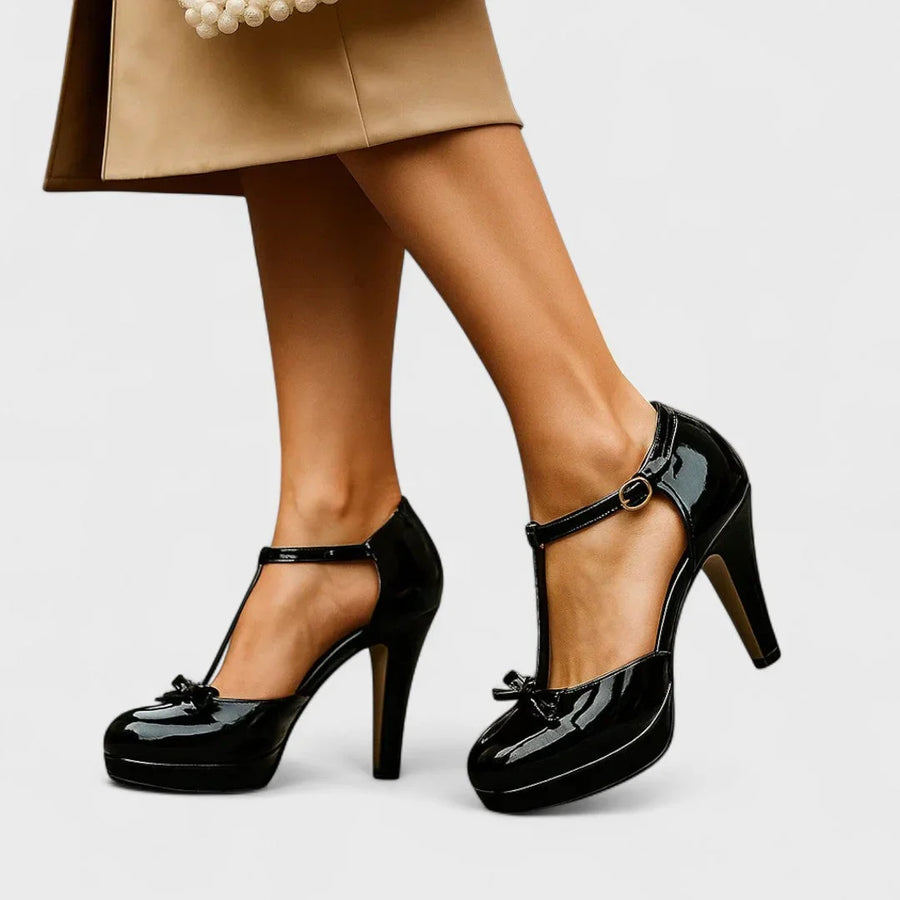 Black Mary Jane heels with ankle strap, round buckle, and glossy platform sole