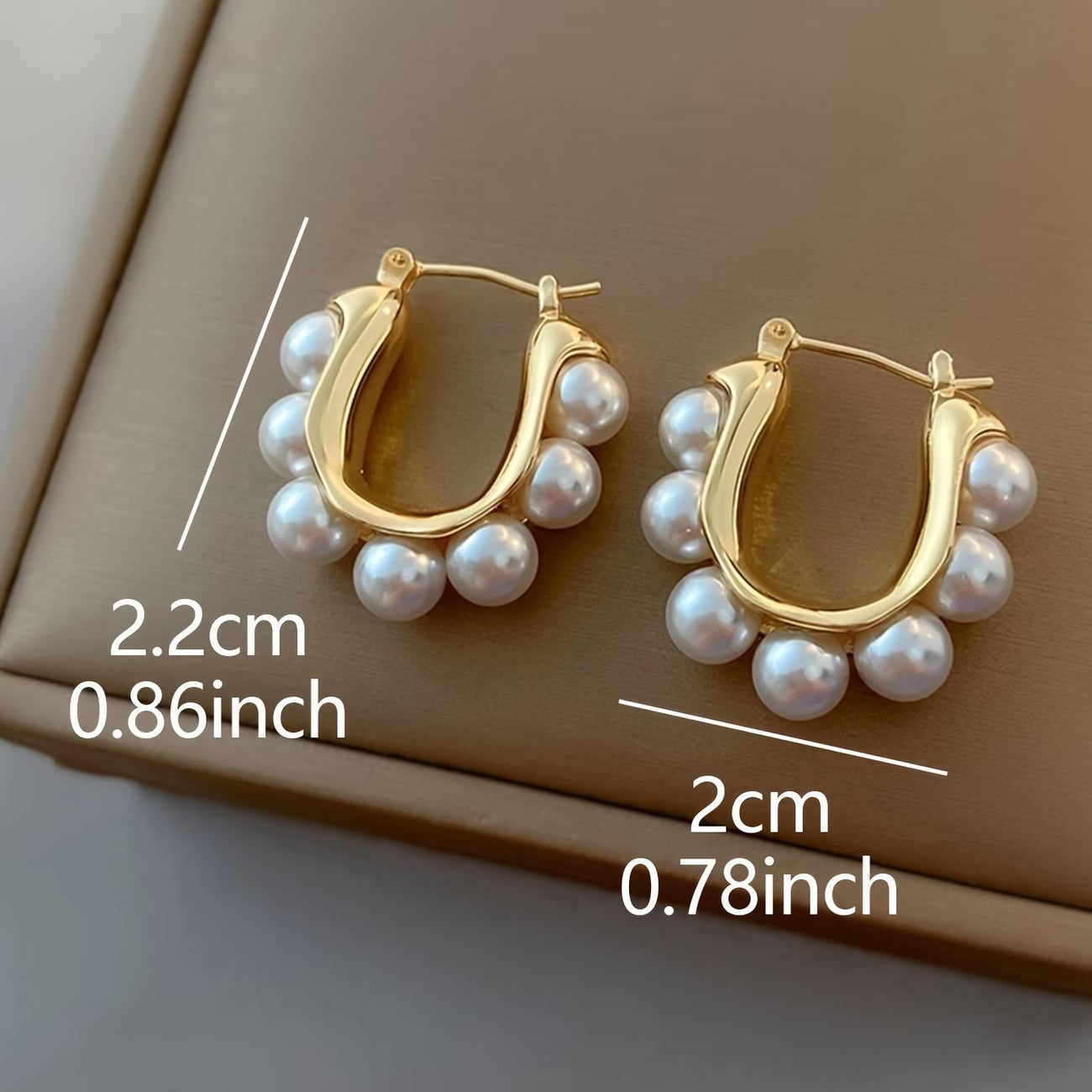 Gold pearl hoop earrings with white pearl clusters and hinged stud back