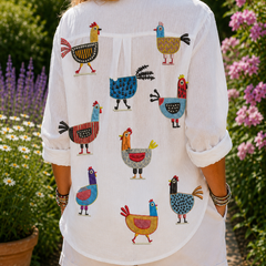 Ingrid hen print blouse, white with colorful rooster pattern on back, button front.