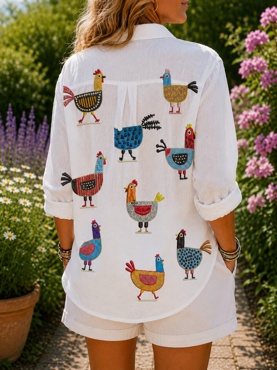 Ingrid hen print blouse, white with colorful rooster pattern on back, button front.
