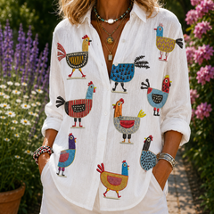 Ingrid hen print blouse in white with colorful rooster and bird pattern, button front.