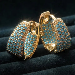 Gold-tone hoop earrings with turquoise bead rows and openwork lattice, side view
