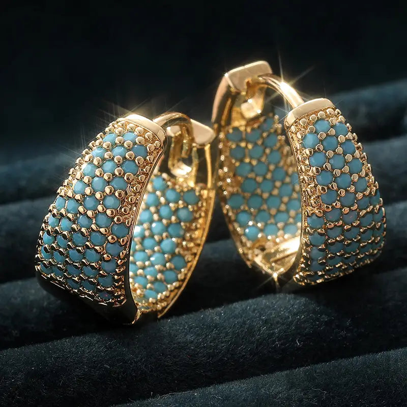 Gold-tone hoop earrings with turquoise bead rows and openwork lattice, side view