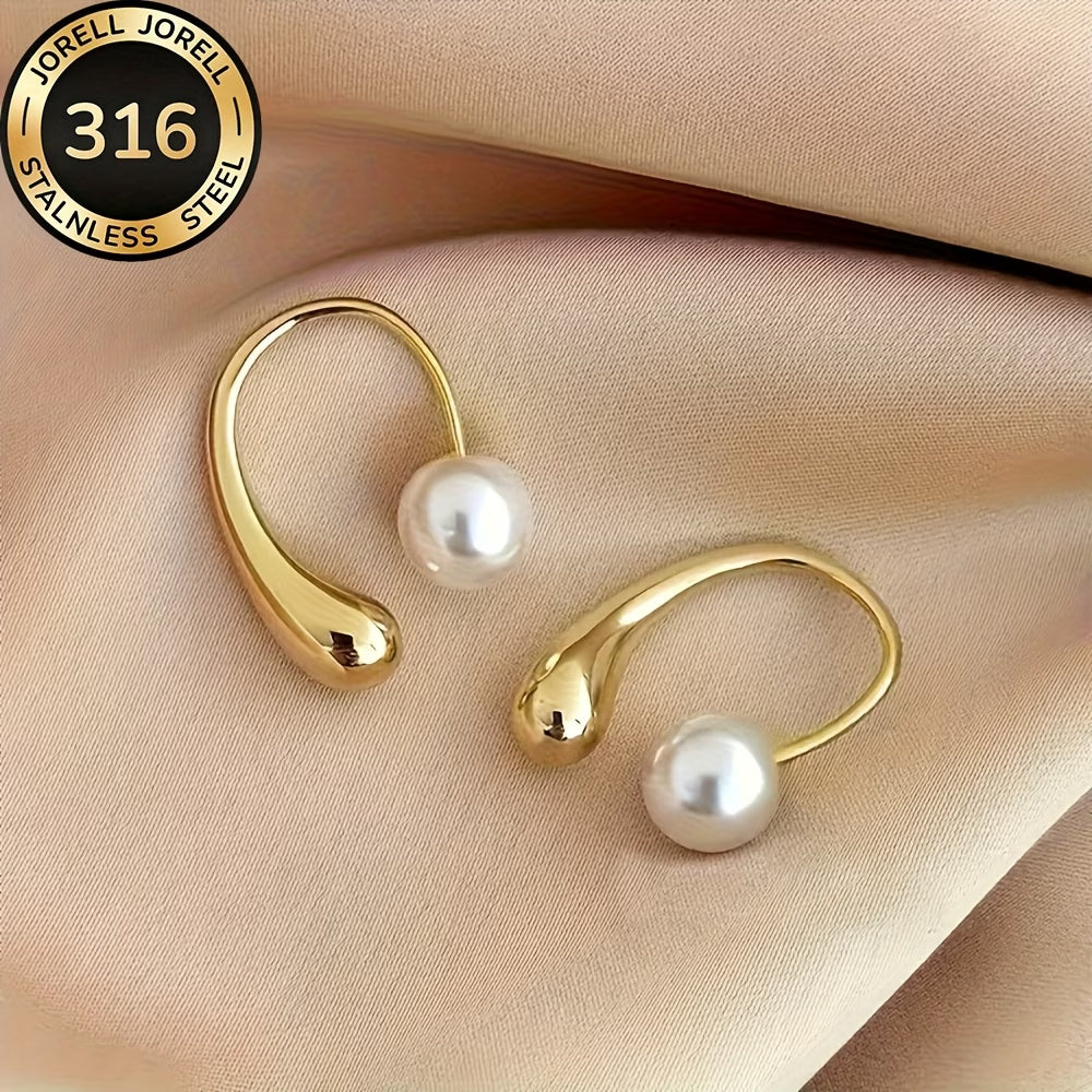 Gold-tone arc hoop pearl earrings, two earrings shown on light fabric