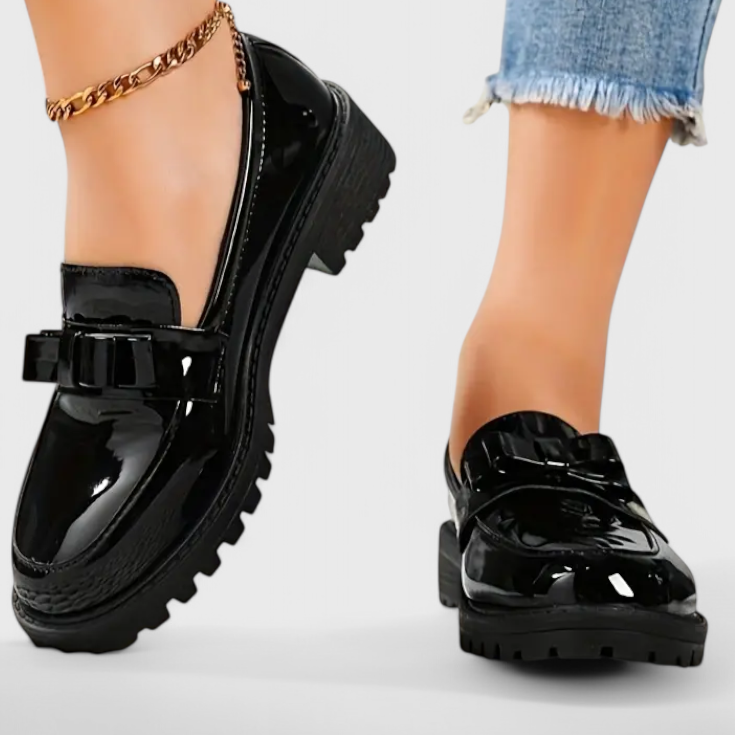 Black patent loafers with chunky block heel, buckle strap, and smooth topline