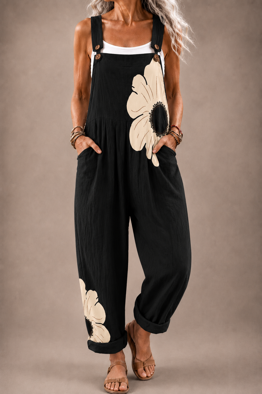 Black floral bib overalls with cream flower print, adjustable straps and wide legs