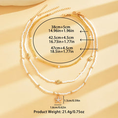 Layered necklace set with white bead chains and gold accents, starfish and shell charms