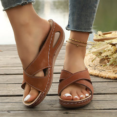 Brown open-toe cross-strap sandals with stitched trim and ankle chain strap