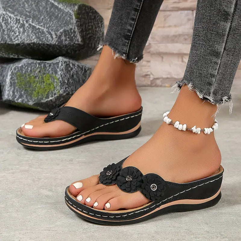 Black comfort sandals with 3D flower strap detail and beaded ankle bracelet