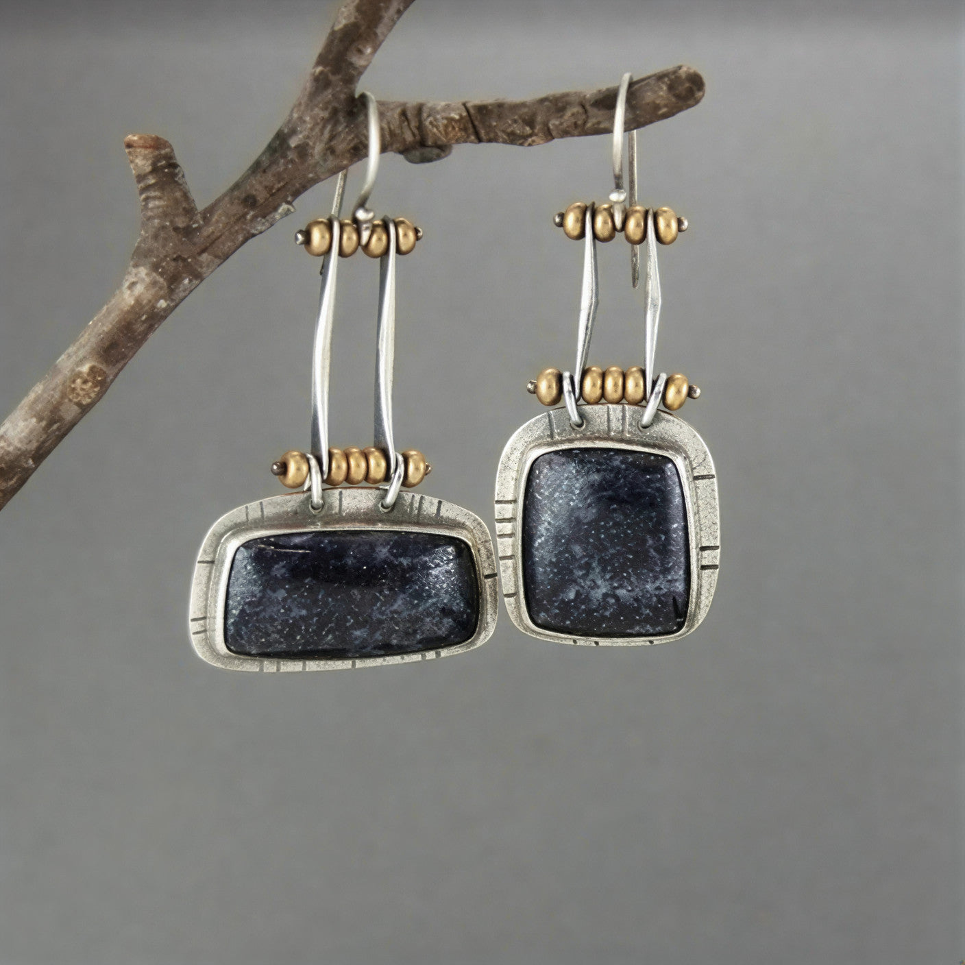 Vintage silver-tone drop earrings with dark oval stones and gold bead accents