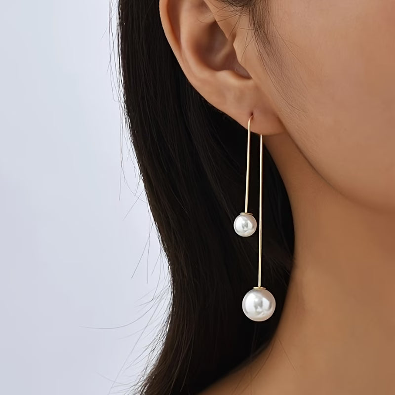 Gold-tone drop earrings with two round white pearls on long hooks