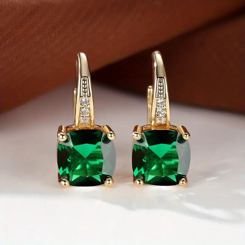 Gold hoop earrings with square green gemstones and small clear stones