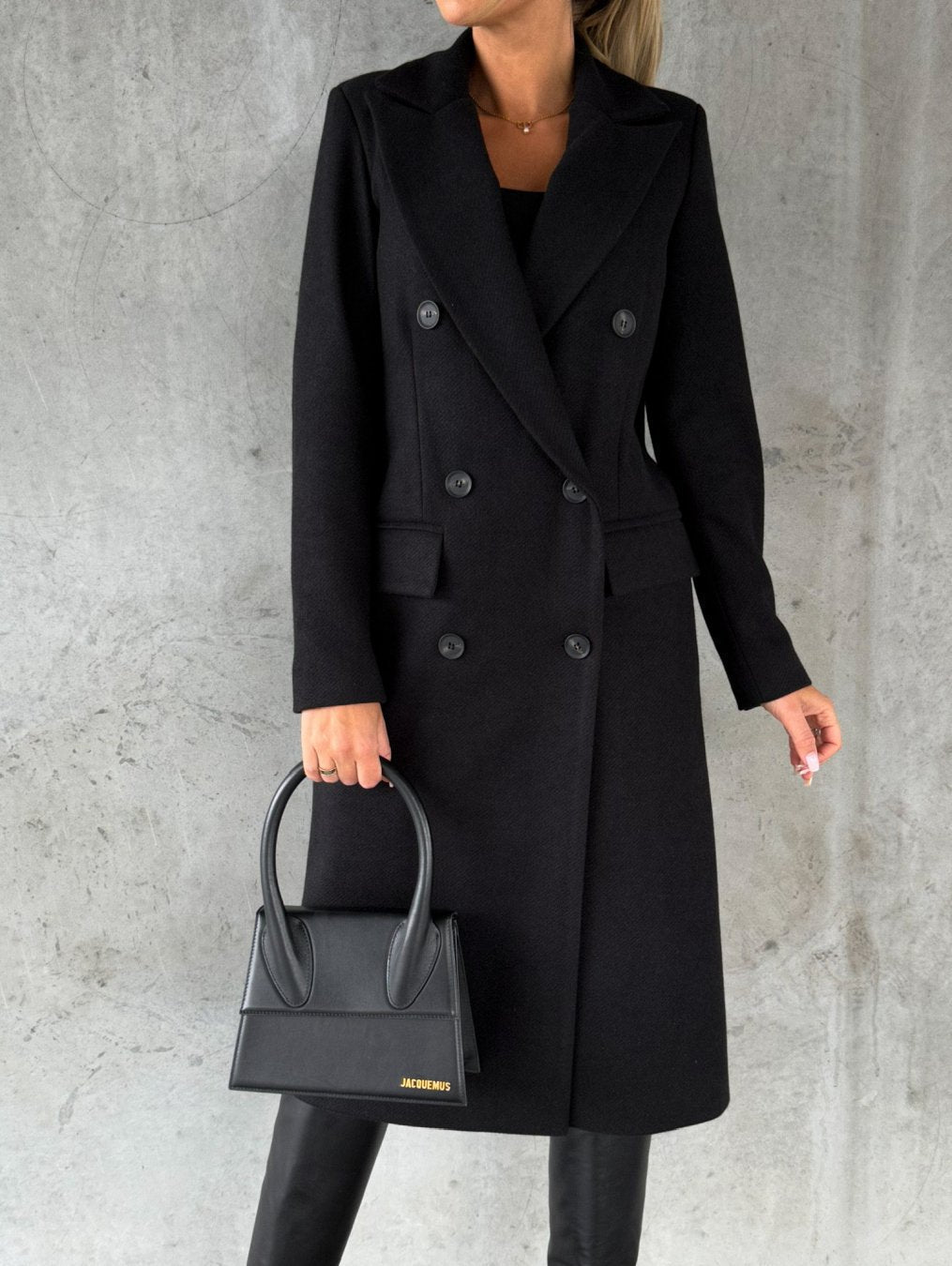 Black long double-breasted coat with notched lapel, button front, side pockets