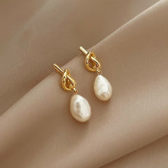 Gold hoop earrings with knotted links and white teardrop pearl drops