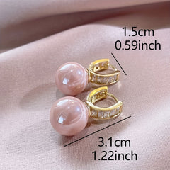 Pink pearl ball drop earrings with gold hinged hoops and square stone settings.