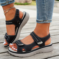 Black sandals with two hook-and-loop straps and open toe on cushioned platform