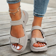 Beige sandals with hook-and-loop straps, open toe, and cushioned platform sole