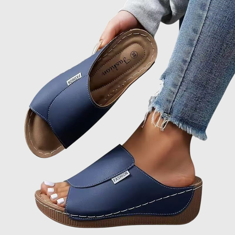 Blue wedge sandals with wide strap and open toe, stitched detail and textured sole