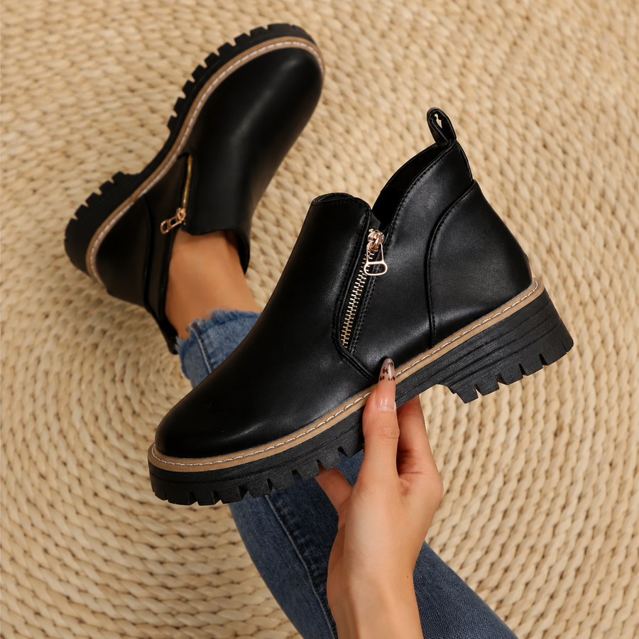 Women's ankle boots, smooth black with side zipper and lugged sole.