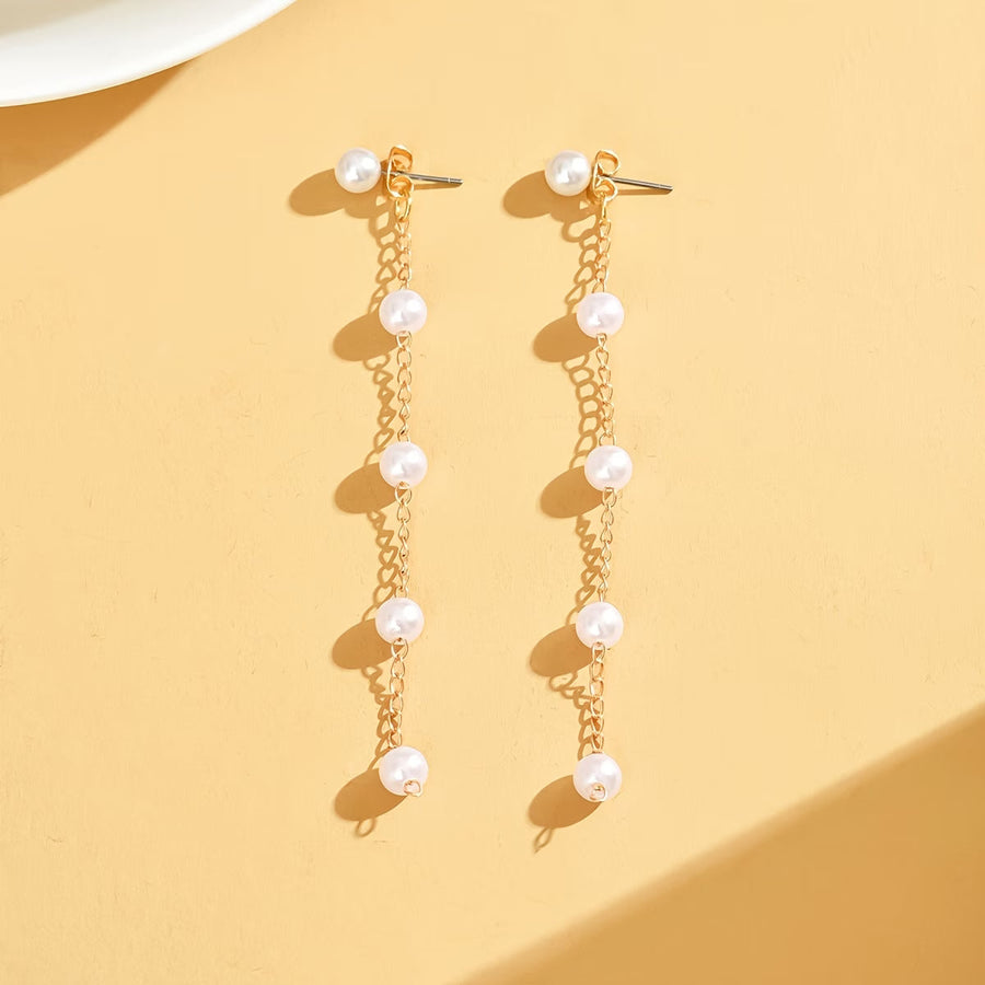 Pair of gold-tone pearl dangle earrings with clustered round white pearl drops.