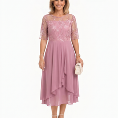 Pink lace midi dress with short sleeves, fitted waist, and layered asymmetrical ruffle skirt