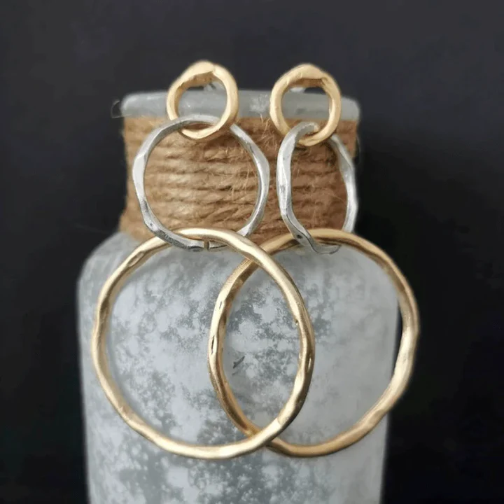 Vintage gold-tone hoop earrings with textured, oval rings and open circular shape