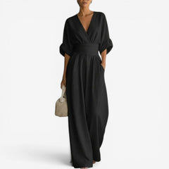 Black V-neck jumpsuit with gathered waist and wide-leg flowy legs.