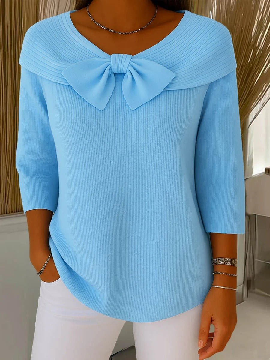 Light blue ribbed tunic top with wide neckline bow detail and three-quarter sleeves