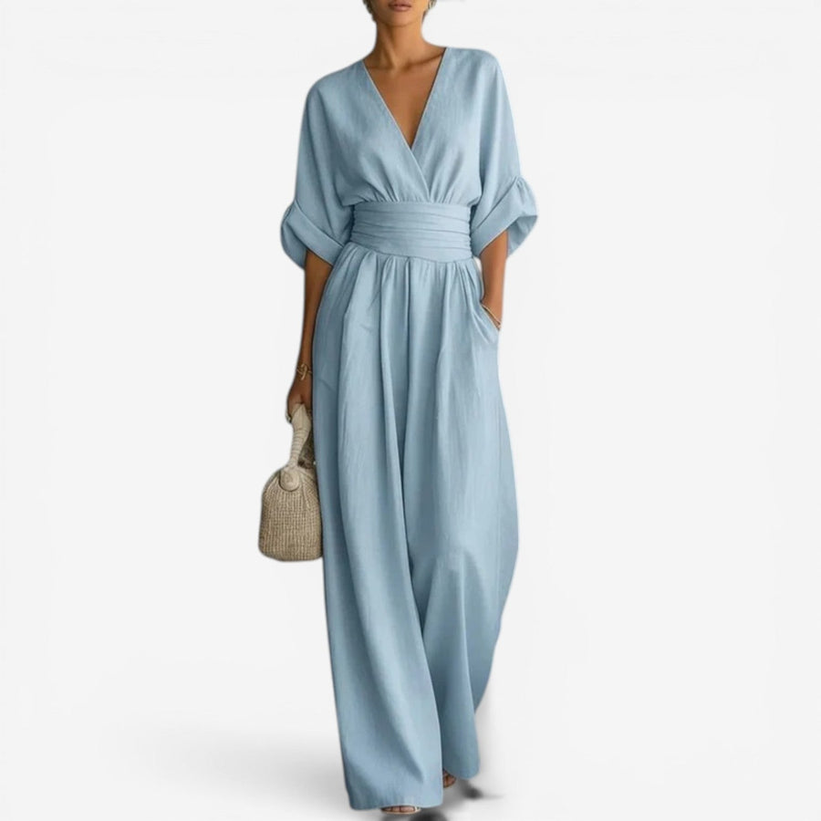 Light blue V-neck jumpsuit with gathered waist and wide-leg drape.