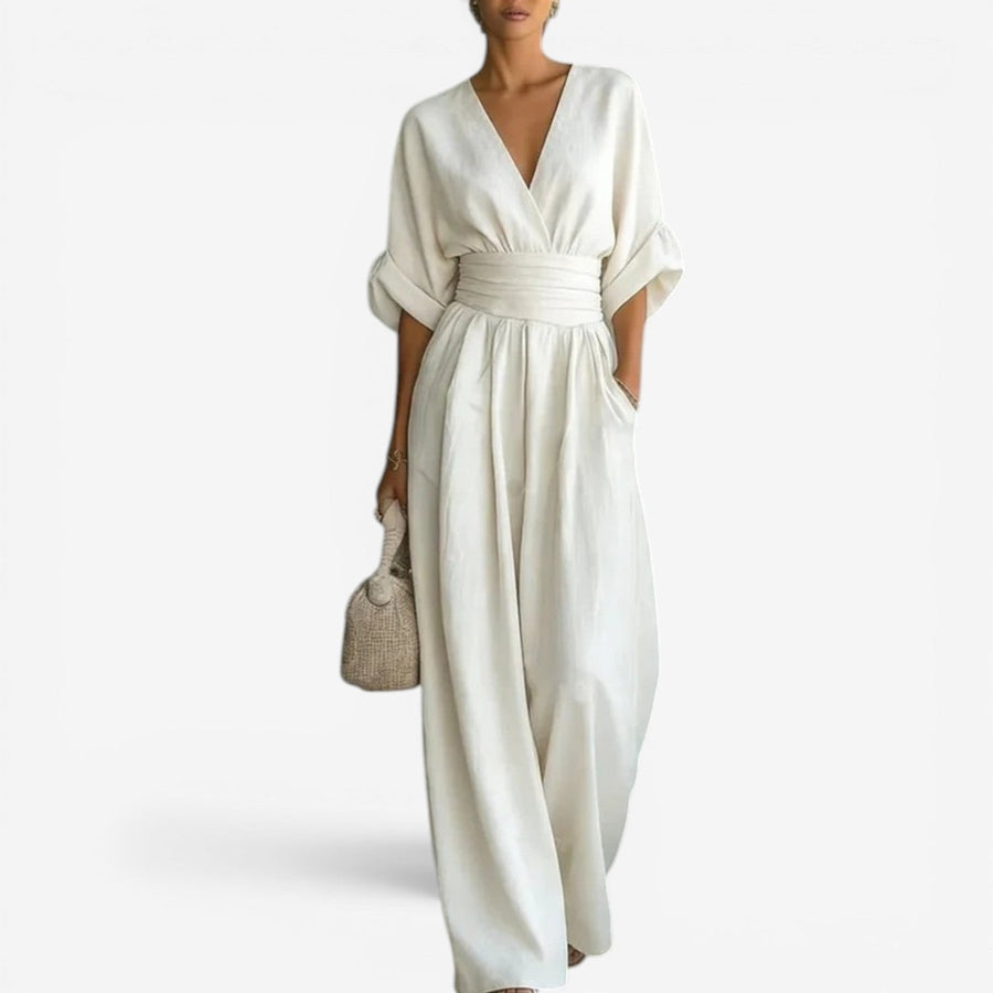 Cream V-neck jumpsuit with gathered waist and wide-leg drape.