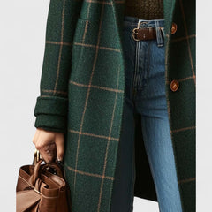 Dark green plaid long coat close-up with brown buttons and cuffed sleeves