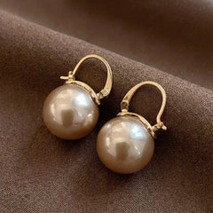 Gold hoop pearl drop earrings with large round white pearls, hinged hoops