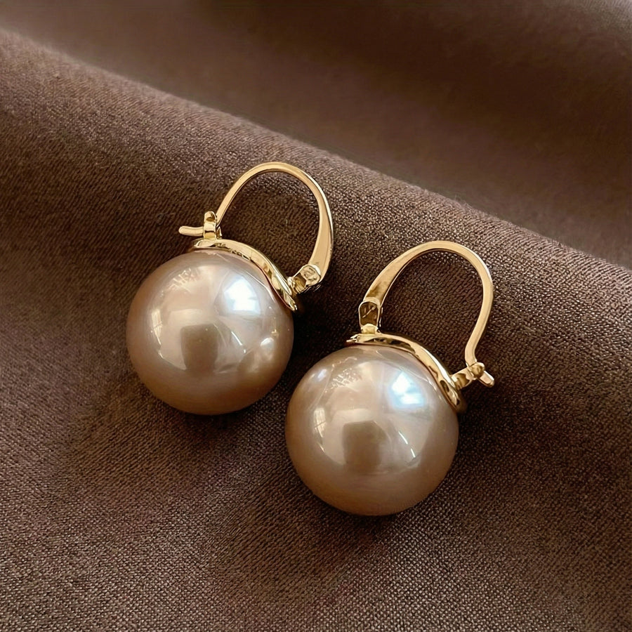 Gold hoop pearl drop earrings with large round white pearls, hinged hoops