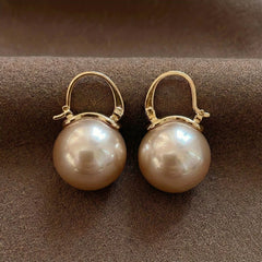 Gold hoop pearl earrings with two large round white pearls, front view