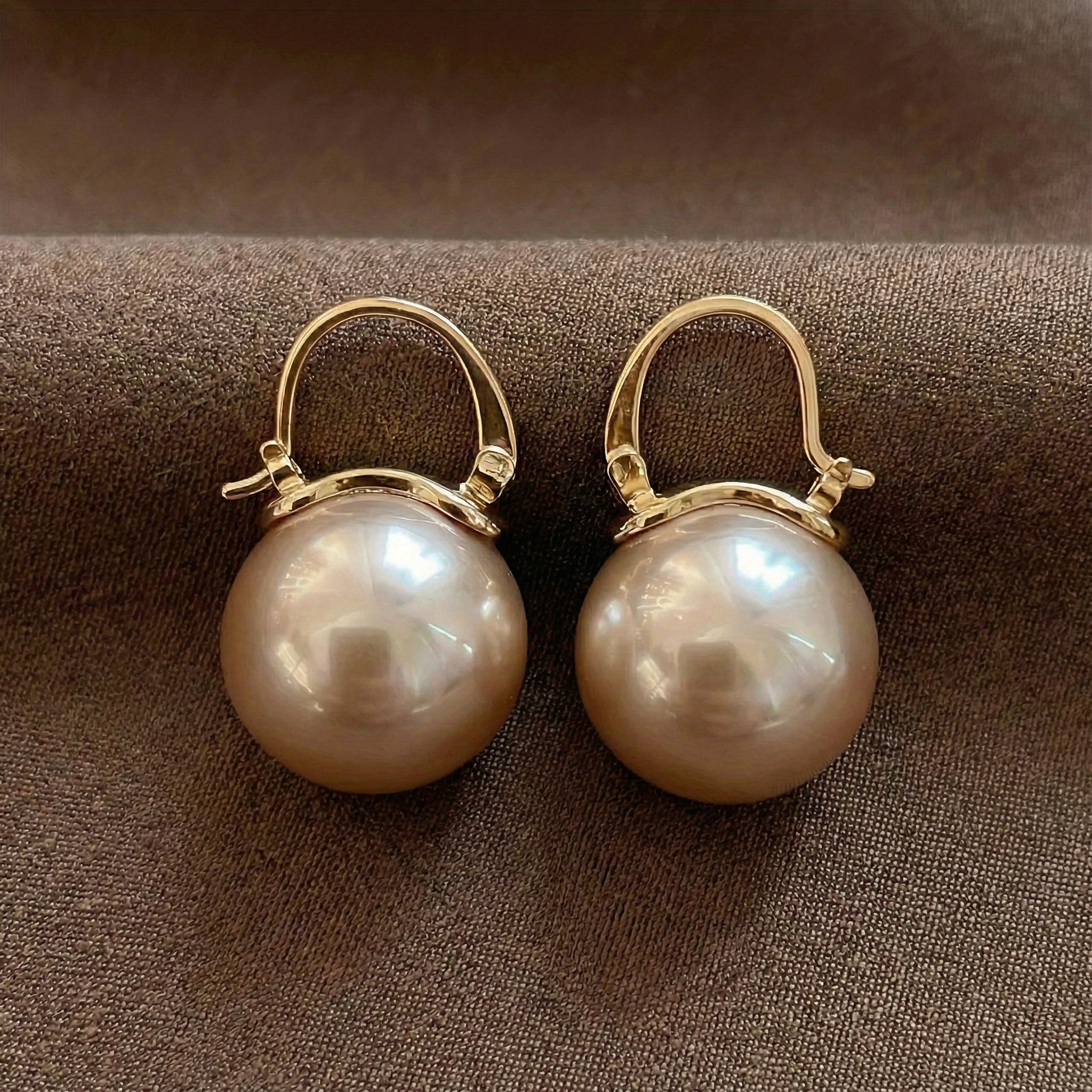 Gold hoop pearl earrings with two large round white pearls, front view