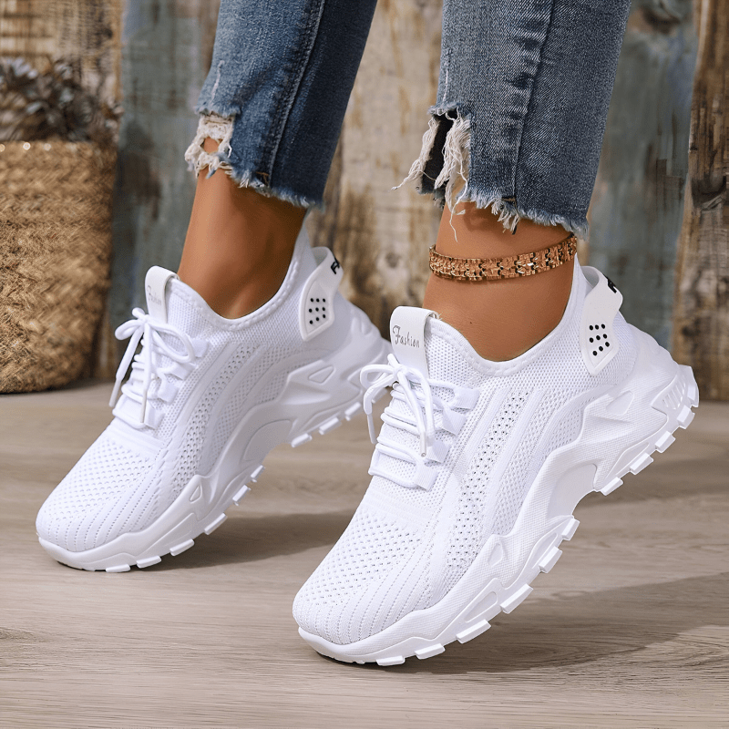 White lace-up sneakers with breathable knit upper and rugged sole