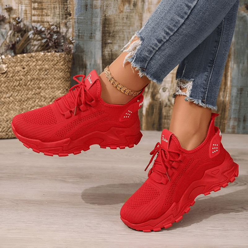 Red lace-up sneakers with breathable knit upper and chunky tread sole