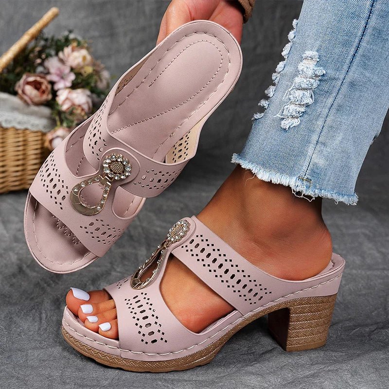 Light pink perforated wedge-style block sandals with rhinestone charm strap