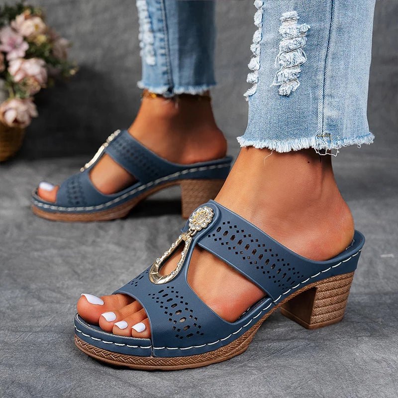 Blue perforated slide sandals with rhinestone charm and chunky mid-height heel