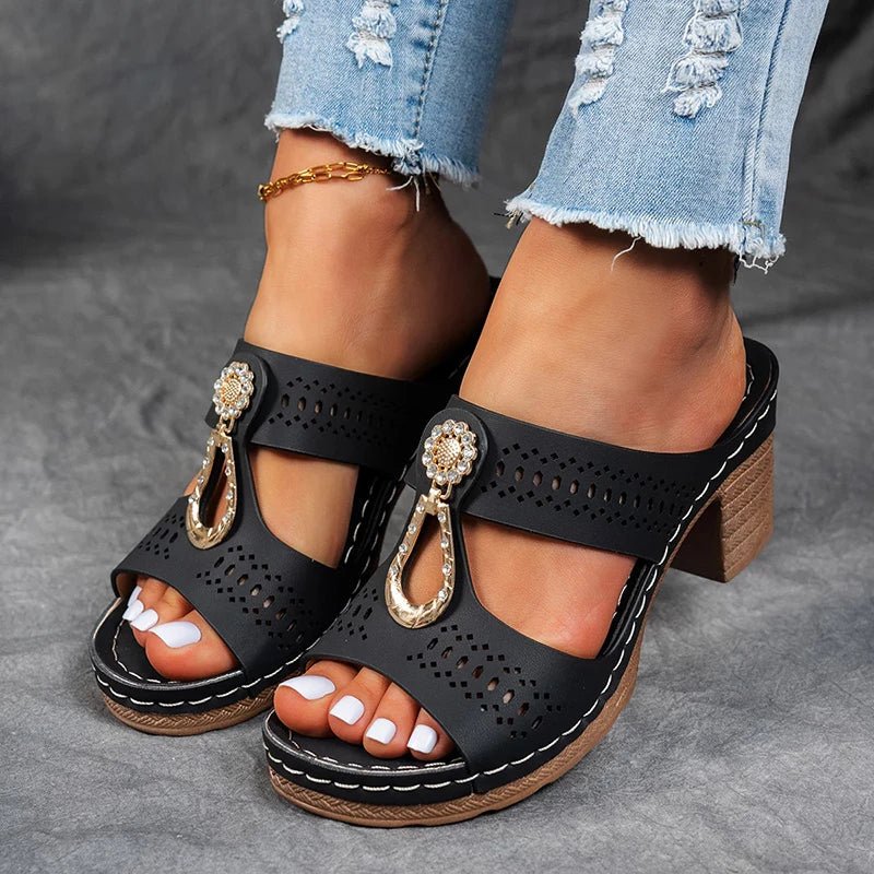 Black perforated slide sandals with decorative charm straps and block heel