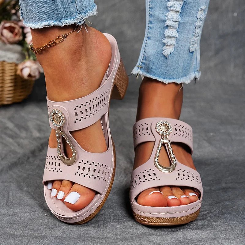 Light pink perforated slide sandals with rhinestone charm and chunky block heel